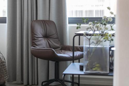 a brown chair sitting in front of a window at Boutique Hotel Herman K in Copenhagen