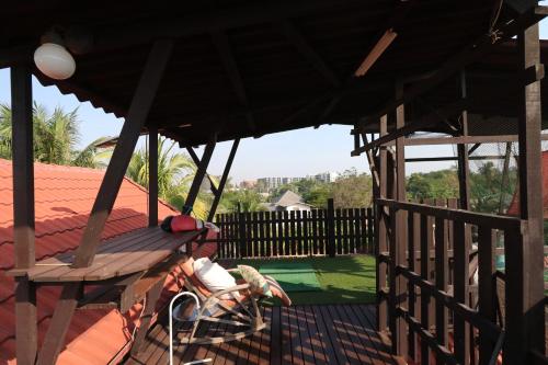 a porch with a wooden bench and a fence at Beach House @ Khao Tao in Khao Tao