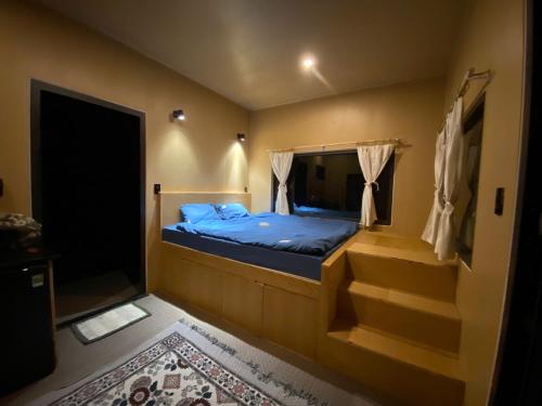 a small bedroom with a bed and a staircase at Sú Mỏ Choi Đà Lạt in Ðơng Tiêng Liêng