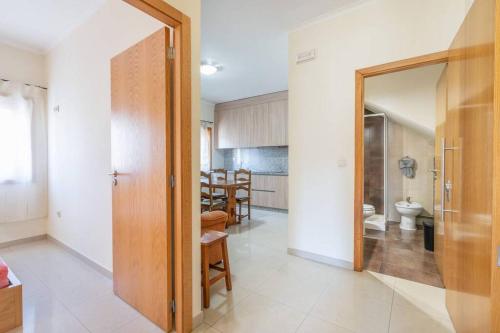 a hallway with a door to a kitchen and a dining room at Cantinho dos Fernandes II in Ponte da Barca
