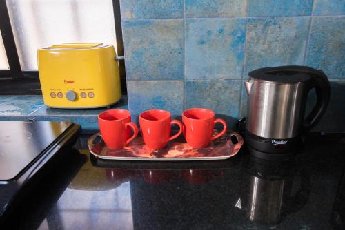 a tray with four coffee cups on a counter at 'Golden Sea Pearl' 1 bhk Beach apartment in Benaulim
