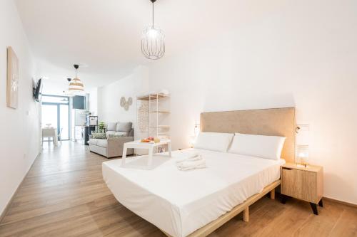 a white bedroom with a large bed and a living room at VisitVal Flats 3 in Valencia