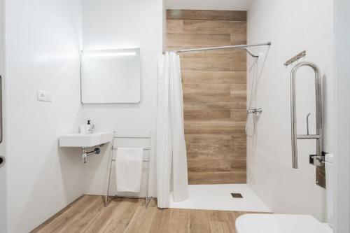 a white bathroom with a shower and a sink at VisitVal Flats 3 in Valencia