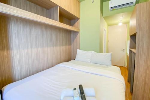 a small bedroom with a bed with white sheets at Fully Furnished with Cozy Design Studio Apartment Tokyo Riverside PIK 2 By Travelio in Rawalembang