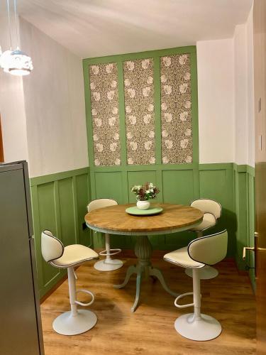a table and chairs in a room with green walls at Ozium in Villa Vicentina