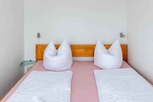 two beds in a room with white pillows at Ferienwohnung Oberdeck in Schilksee