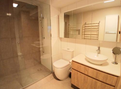 a bathroom with a toilet and a sink and a shower at ReadySet Apartments at Southbank Condos in Melbourne