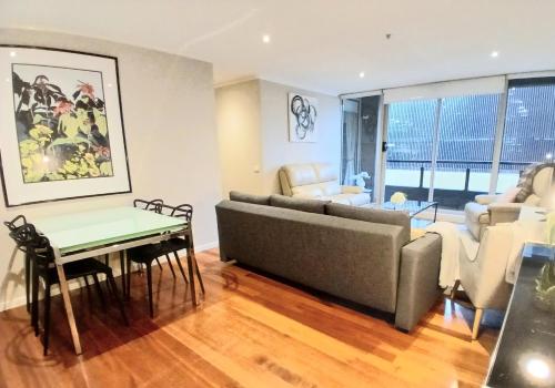 a living room with a couch and a table at ReadySet Apartments at Southbank Condos in Melbourne