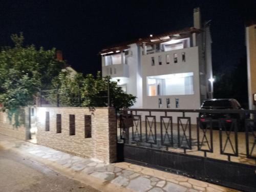 a building with a fence in front of it at night at Panagio House in Pefki