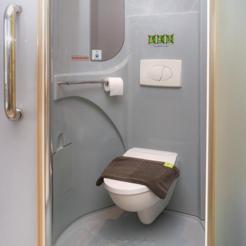 a small bathroom with a toilet with a brown towel at POP! Hotel Banjarmasin in Banjarmasin
