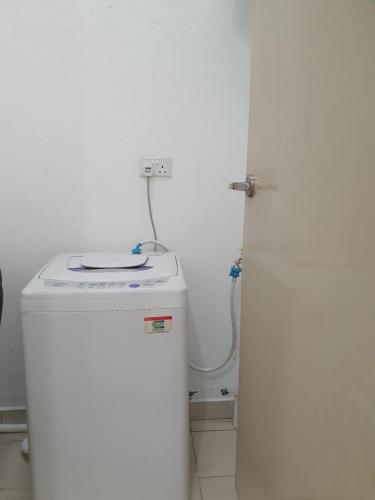 a small white bathroom with a washer and a white refrigerator at Southbay Seaview Condo A2 10minQueensbay 10minSpice in Bayan Lepas