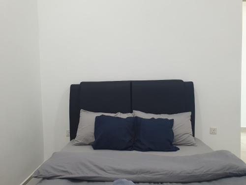 a bed with a black headboard and blue pillows at Southbay Seaview Condo A2 10minQueensbay 10minSpice in Bayan Lepas