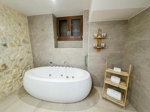 a bathroom with a large white tub in a room at Komody in Delfoi
