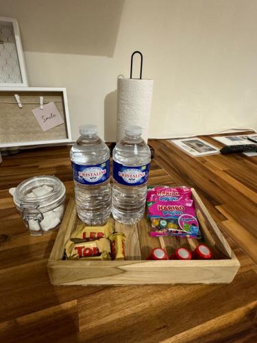 - deux bouteilles d'eau et quelques collations sur une table dans l'établissement Cocoon Room - jacuzzi, à Sémoy