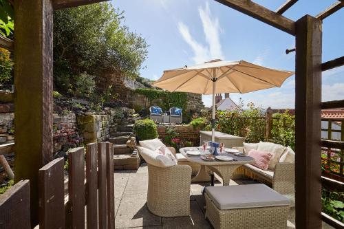 a patio with a table and an umbrella at Host & Stay - Voyagers' View in Whitby