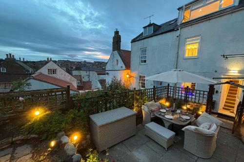 a patio with a table and chairs in front of a building at Host & Stay - Voyagers' View in Whitby