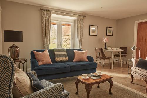 a living room with a blue couch and a table at Cliff Farmhouse B&B Suites in Hunstanton