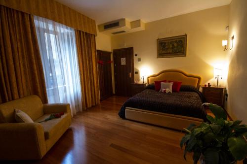 Camere al Borgo في Forchia: غرفة نوم بسرير وكرسي وأريكة