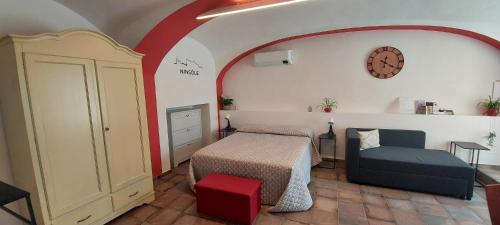 a bedroom with a bed and a chair and a clock at Ninsòle in La Morra