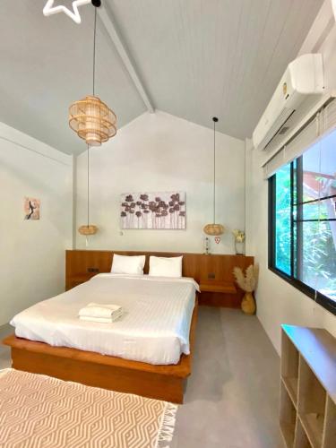 ein Schlafzimmer mit einem weißen Bett und einem großen Fenster in der Unterkunft Tropical Crystal Villa with Terrace Kitchen in Ko Phangan