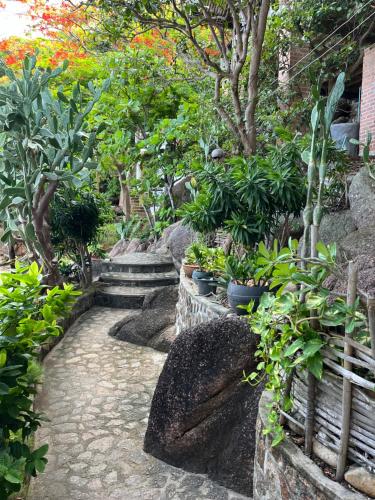 a garden with potted plants and trees and rocks at Tao Thong Villa 1 in Koh Tao
