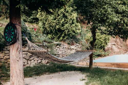 a hammock hanging from a pole next to a tree at Dom w Dolinie in Trzcińsko