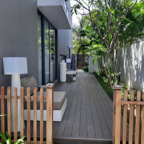 a wooden deck with a bench and a house at Villa 4 Phòng Ngủ Sanctuary Hồ Tràm - Cách Biển 70m in Ho Coc