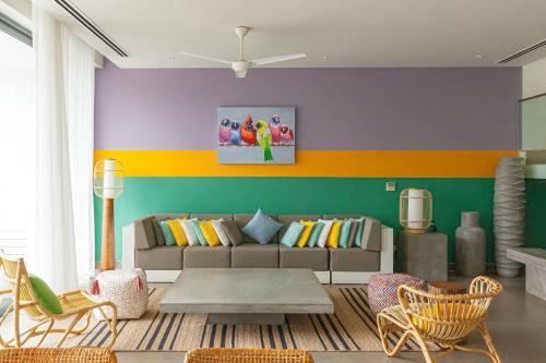 a living room with a couch and a colorful wall at Villa 4 Phòng Ngủ Sanctuary Hồ Tràm - Cách Biển 70m in Ho Coc