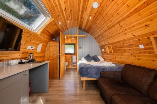 a room with a bed and a couch in a cabin at The Kellbank in Gosforth