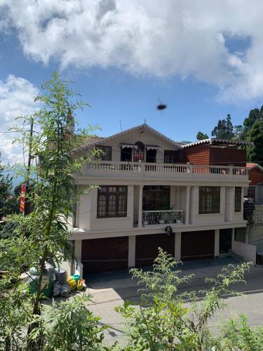 a large house with a balcony on top of it at Donna's Homestay in Ghum