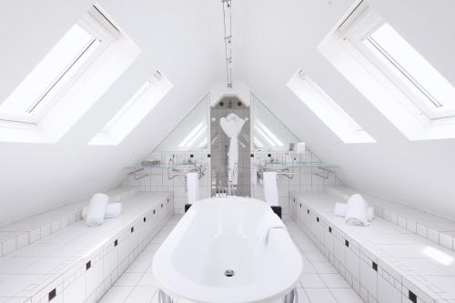 a white bathroom with a clock tower in the background at L'Agapa Hôtel - Spa Codage in Perros-Guirec