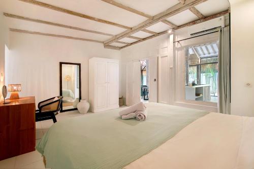 a bedroom with a large bed and a desk at Villa Maison Pastis Canggu in Canggu
