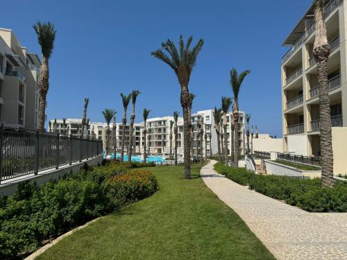 エル・アラメインにあるEmaar Marassi Garden viewのマンションの前のヤシの木が並ぶ小道