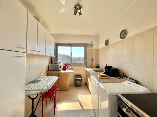 - une cuisine avec des appareils électroménagers blancs et une table dans l'établissement Méditerranée by Welcome to Cannes, à Cannes