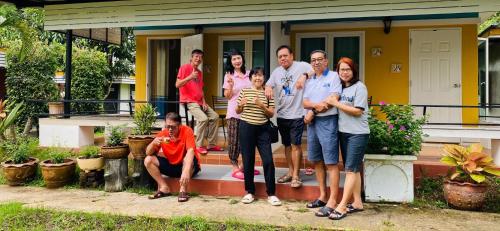 a group of people standing on the steps of a house at Panutsaya Homestay in Wang Nam Khieo