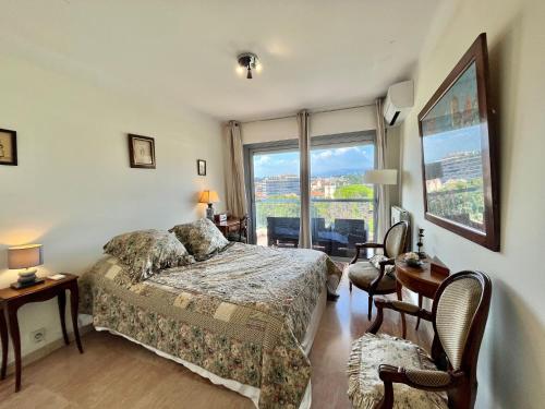 une chambre avec un lit et une grande fenêtre dans l'établissement Méditerranée by Welcome to Cannes, à Cannes