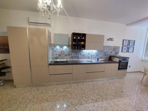 une cuisine avec des armoires blanches et un comptoir noir dans l'établissement Calipso casa vacanza, à Marina di San Vito