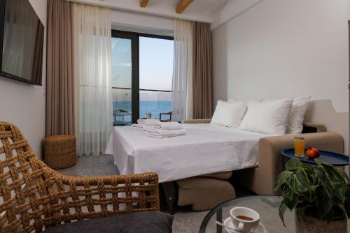 a hotel room with a bed and a large window at Soho SeaFront Suites in Hersonissos