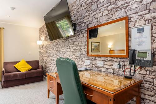 a stone wall with a desk and a mirror at The Kellbank in Gosforth