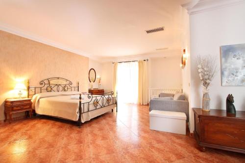 Un dormitorio grande con una cama y un sofá. en Villa Can Josep - Maldonado, en Pollensa