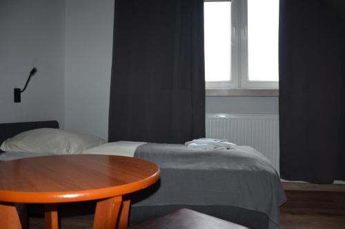 a room with a table and a bed and a window at Zielony Dom in Bolesławiec