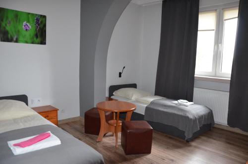 a hotel room with two beds and a table at Zielony Dom in Bolesławiec