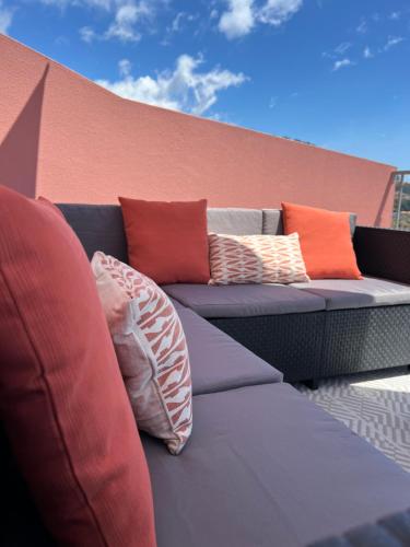 a couch with colorful pillows sitting on a balcony at Mine House in Calheta