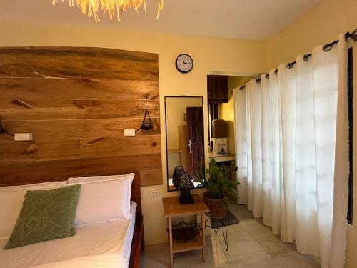 una camera con un letto con una grande testiera in legno di Cozy Bungalow Isa with AC and Generator in General Luna a General Luna