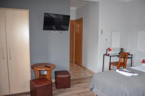 a bedroom with a bed and a tv on the wall at Zielony Dom in Bolesławiec