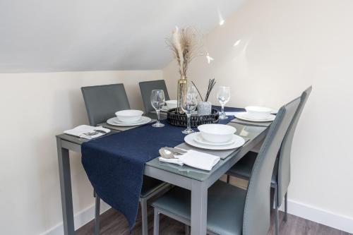 a dining room table with a blue table cloth and chairs at Spacious City Centre 2 Bedroom Penthouse with Cathedral Views in Canterbury