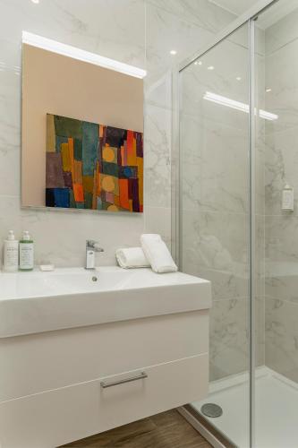 a white bathroom with a sink and a shower at ARMONIA Casa Vacanze in Passo Corese