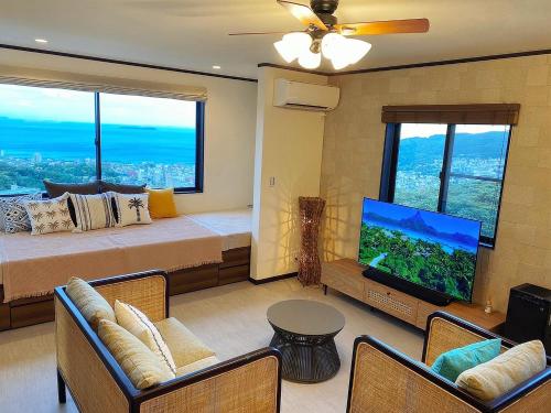 a bedroom with a bed and a flat screen tv at RetreIto Resort in Ito
