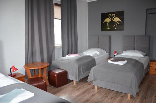 a hotel room with three beds and a chair at Zielony Dom in Bolesławiec