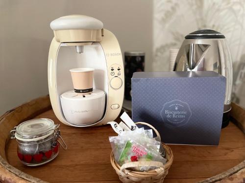 - une cafetière et une boîte sur une table dans l'établissement La suite des Chapitres en Champagne, à Courmas
